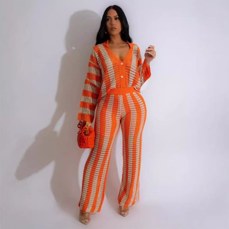 Striped orange and white jumpsuit with wide-leg pants and long sleeves.