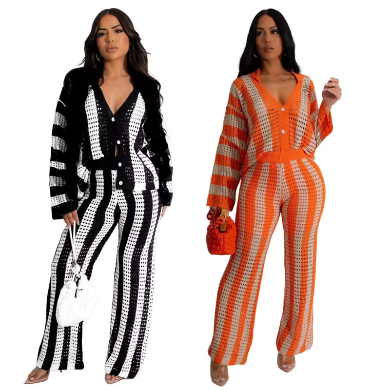 Two women wearing striped jumpsuits, one in black and white and one in orange and white.