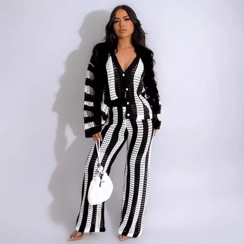 Woman wearing a black and white striped knit cardigan and matching wide-leg pants.