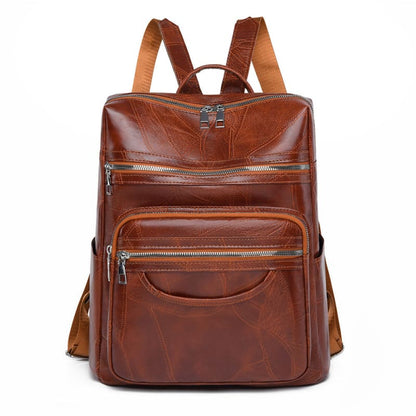 Brown leather backpack with multiple zippered compartments and adjustable straps.