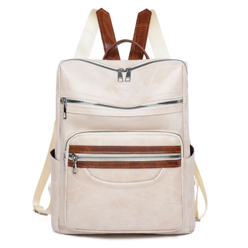 Beige backpack with brown leather straps and multiple zippered compartments.