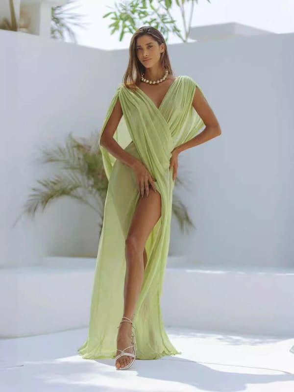 Flowing lime green wrap dress with a high slit.