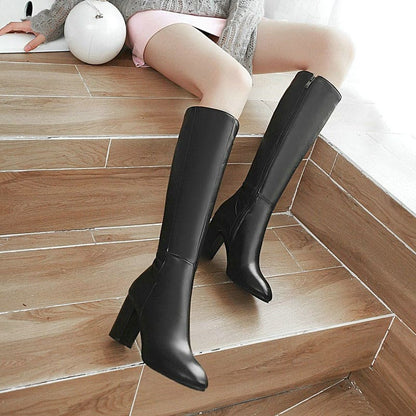 Pair of black knee-high boots with chunky heels.