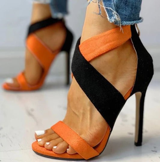 Stylish high-heeled sandal with orange and black straps.