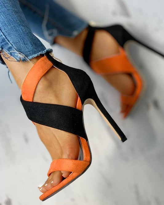 Stylish high-heeled sandals with orange and black straps.