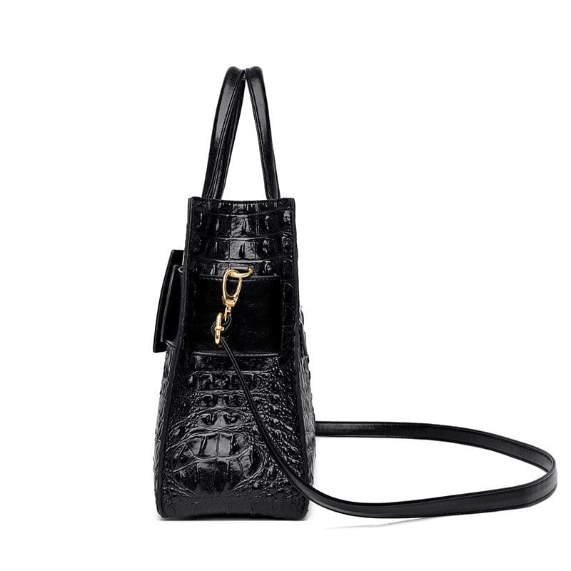 Black leather handbag with crocodile texture and gold hardware.