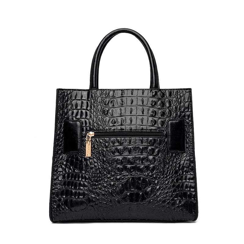 Black crocodile-embossed leather handbag with structured shape and gold hardware.