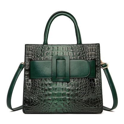 Dark green crocodile-textured leather handbag with a prominent front buckle and shoulder strap.