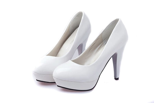 Pair of white high-heeled platform pumps.