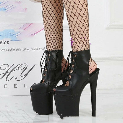 Extremely high platform stiletto boots with lace-up front and fishnet stockings.