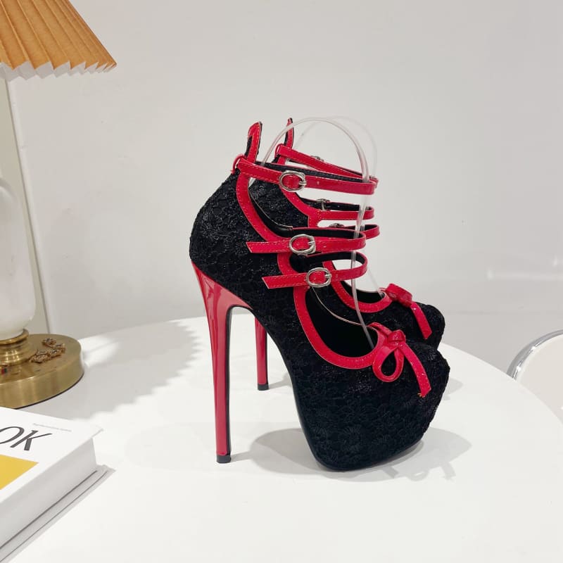 High-heeled platform shoe with black fabric and red straps.