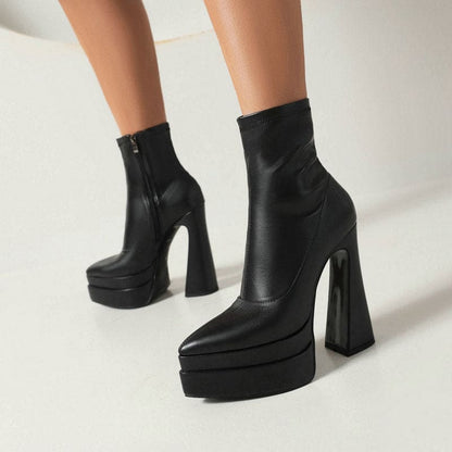 Black leather platform ankle boots with extremely high chunky heels.