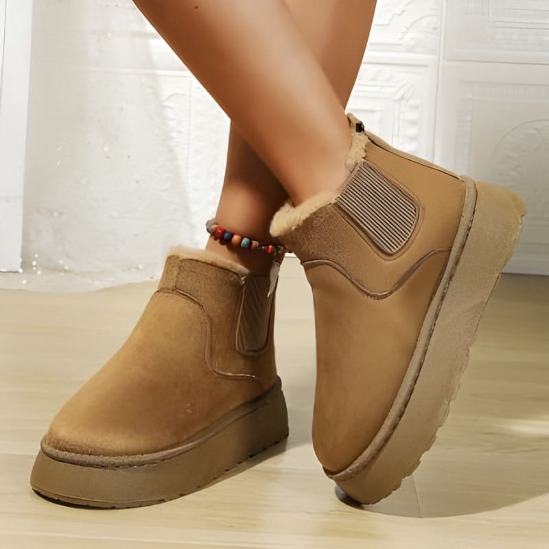 Pair of tan ankle boots with thick soles and elastic side panels.